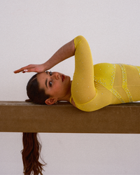 Justaucorps gymnastique Sunflower Hooje jaune — porté sur praticable de gymnastique